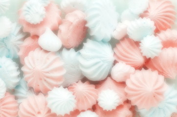 Closeup of mini meringues cakes in blue pink pastel colors on white as food background blur effect.