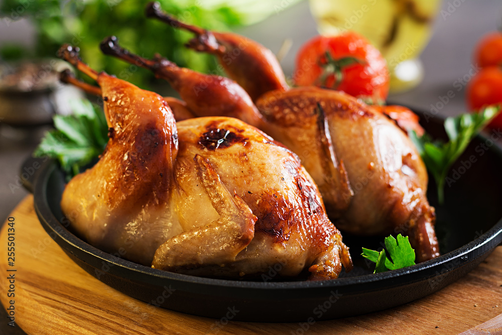 Wall mural baked quails in pan on a dark background