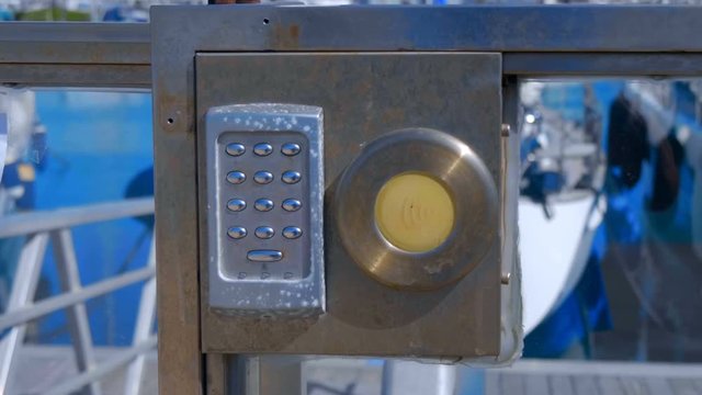 Chrome metal buttons of the electronic lock on the iron door at the entrance to the yacht club of the seaport of Valencia, Spain. Shot in motion