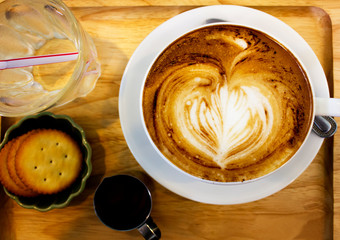Cup of cappuccino coffee with heart shape latte art on old wood table Background, Latte coffee on old wooden Background table