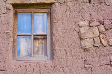Adobe wall with a window. Abandoned house.