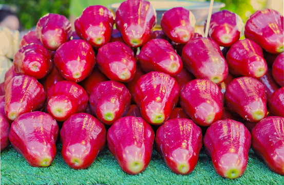 Fresh red Thai rose apple is Semarang rose-apple, Wax jambu, Java apple (Syzygium samarangense) that is edible tropical fruit look likes small pear with delicious sweet taste sale at Thai local market