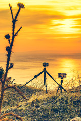 Camera taking picture film of sunrise over sea surface