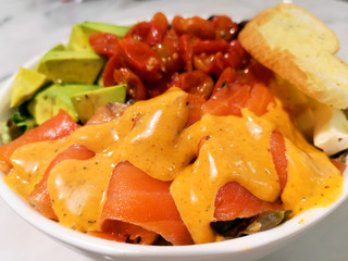 Salmon Salad with spinach, cherry tomatoes, garlic bread, avocado salad. Concept for a tasty and healthy meal. 
