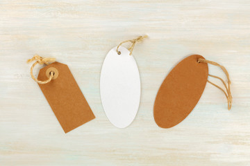 Brown craft paper and white labels. Price tags shot from the top on a white wooden background with copy space