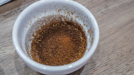 Freshly roasted coffee beans on a coffee white cup on a wooden table ready for a coffee tasting for connoisseurs