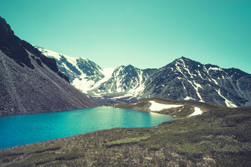 absolutely smooth mirror-like surface of highlands lake, cloudy sky, clay shore, distant mountains,...