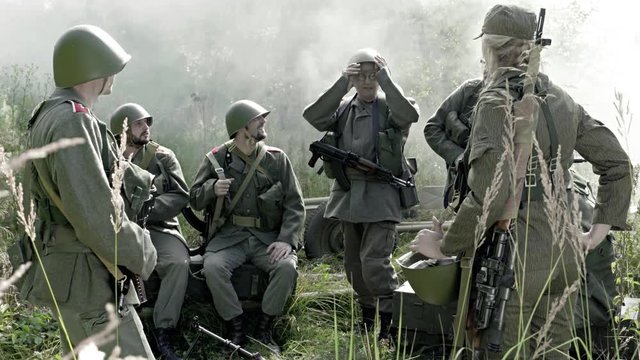 Soldier in a camp is telling jokes to others