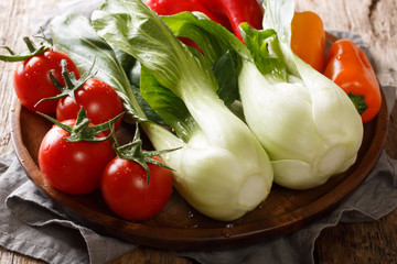 Raw vegetables for the preparation of baby bok choy, tomato and pepper close-up on a plate. horizontal