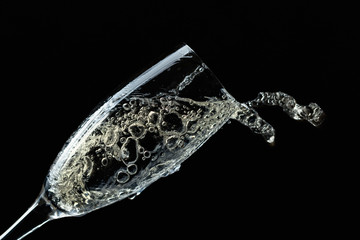 Splashing champagne on black background.