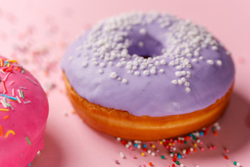Concept of cooking, baking and food - close-up. Donut in purple glaze on a pink background. Trend colors.