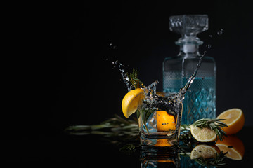 Cocktail gin-tonic with lemon slices and twigs of rosemary.