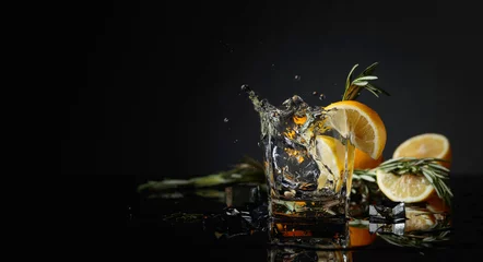 Foto op Plexiglas Cocktail gin-tonic with lemon slices and twigs of rosemary. © Igor Normann