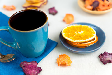 Healthy food organic nutrition. Sliced and dried apple, orange, carrot and beetroot  and cup of tea on textile tablecloth.