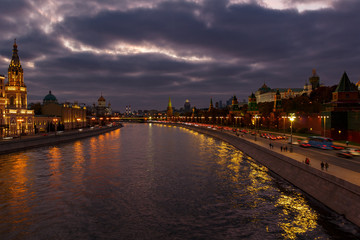 View of Moscow Kremlin and Moskva river embankments in evening against cloudy sky