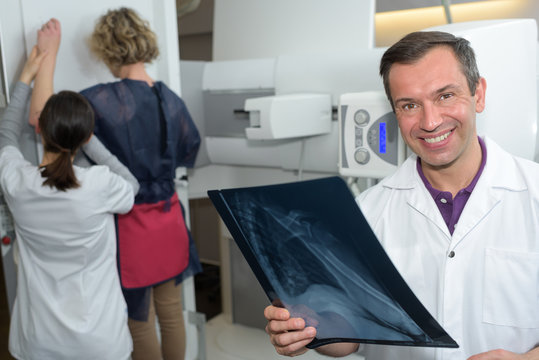 woman undergoing mammography scan assisted by male doctor