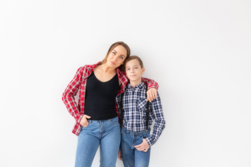 Naklejka premium Family, fashion and mothers day concept - Portrait of mother and son dressed in plaid shirts on white background with copy space