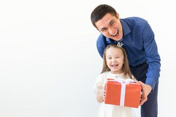 peopel, fatherhood and family concept - happy dad holding a gift box with his daughter on white background with copy space