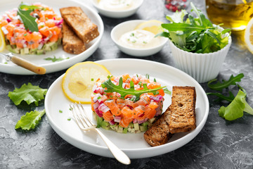 Salmon tartare with red onion, avocado, arugula and bread toast.