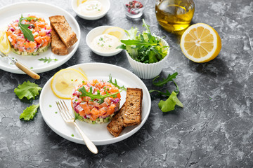 Salmon tartare with red onion, avocado, arugula and bread toast.
