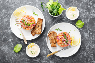 Salmon tartare with red onion, avocado, arugula and bread toast.