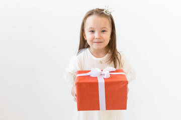 Holiday and presents concept - Little girl smile and holding red gift box