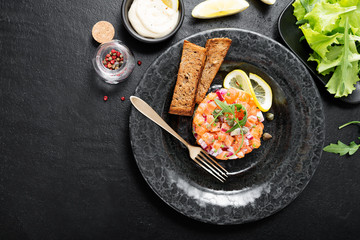 Salmon tartare with red onion, avocado, arugula and bread toast.
