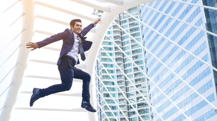 Fototapeta na wymiar lifestyle business man feel happy jumping in air celebrating success and achievement on business district , business concept.