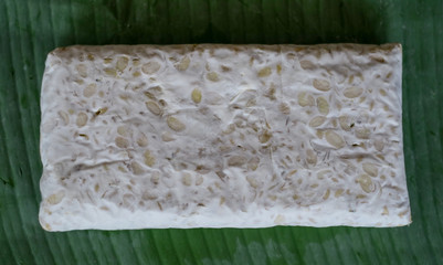 Raw tempeh on banana leaf. Tempeh is a traditional soy product originating from Indonesia.
