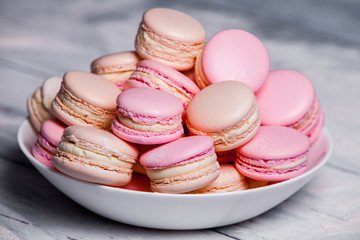 Macaron cookies in white bowl Sweet and colorful french macaroons Close up colorful macarons dessert with vintage pastel tones
