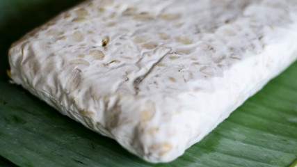 Raw tempeh on banana leaf. Tempeh is a traditional soy product originating from Indonesia.