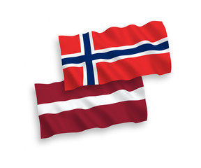 National vector fabric wave flags of Latvia and Norway isolated on white background. 1 to 2 proportion.