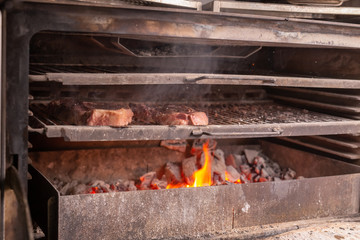 food, craft and delicious concept - cooking steak on a grill