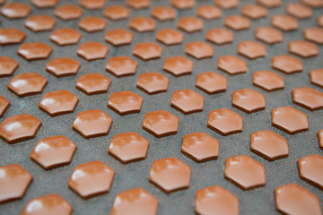 Many smooth stone hexagons on the leather surface. Side view.