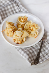 Pancakes stuffed with a bag on a white plate with meat filling