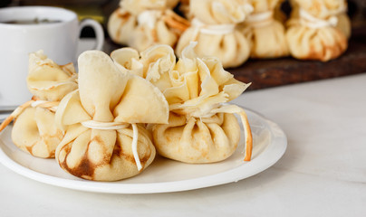 Pancakes stuffed with a bag on a white plate with meat filling
