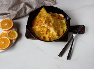 Traditional French crepes Suzette with orange sauce in cast iron skillet