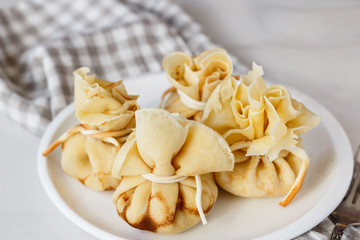 Pancakes stuffed with a bag on a white plate with meat filling