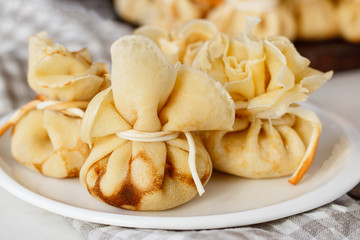 Pancakes stuffed with a bag on a white plate with meat filling