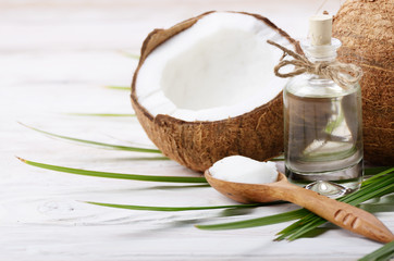 Coconut shell pieces and palm leaves on white wooden table