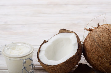 Background of coconut, coconut shell, hard oil in airtight glass jar on white wooden table