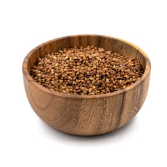 Raw buckwheat in a wooden plate isolated on white background