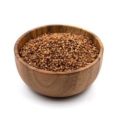 Raw buckwheat in a wooden plate isolated on white background