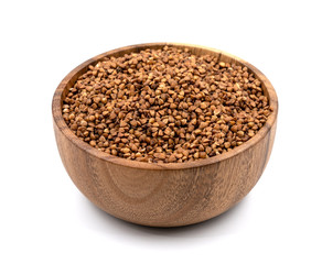 Raw buckwheat in a wooden plate isolated on white background
