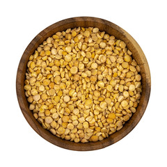 Raw yellow split peas in a wooden plate (bowl) isolated on white background, top down view