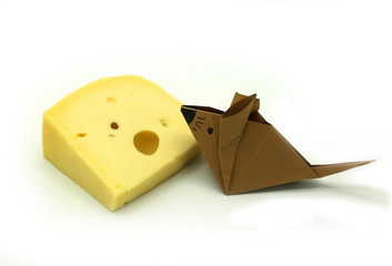 Brown paper origami mouse near a big slice of cheese.