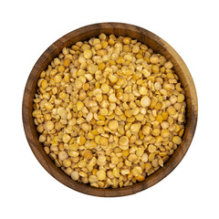 Raw yellow split peas in a wooden plate (bowl) isolated on white background, top down view