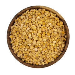 Raw yellow split peas in a wooden plate (bowl) isolated on white background, top down view
