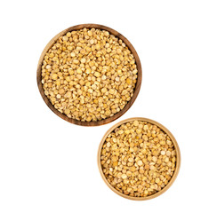Raw yellow split peas in a wooden plate (bowl) isolated on white background, top down view