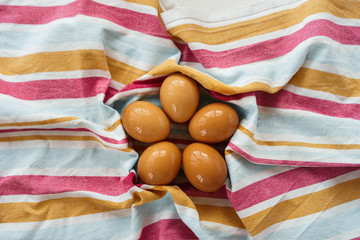 Wet unpainted eggs lie on a striped towel. View from above. Flat lay.  Easter concept. Eco-friendly concept